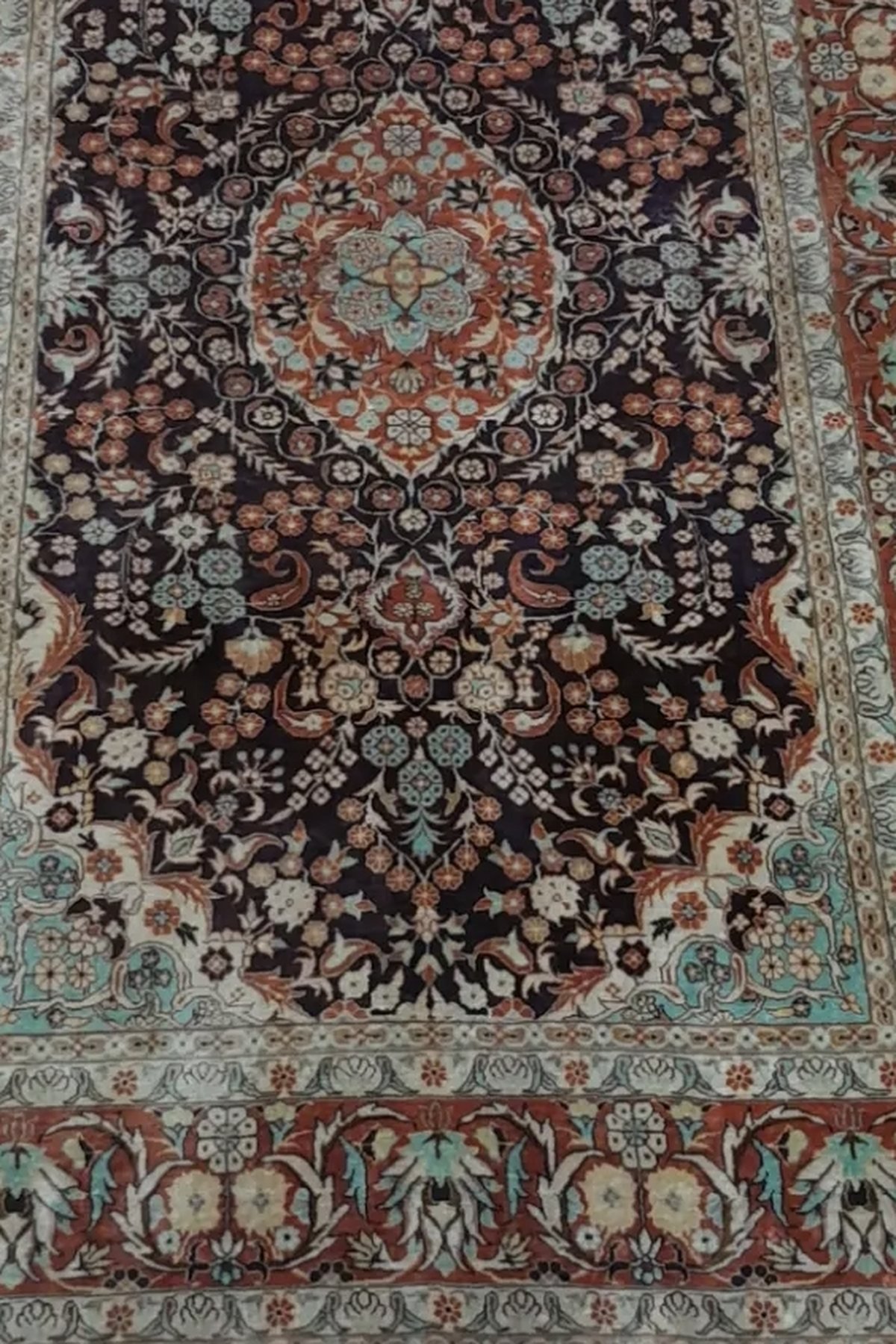 The same rug after a deep restoration wash, showing a navy field and terracotta border