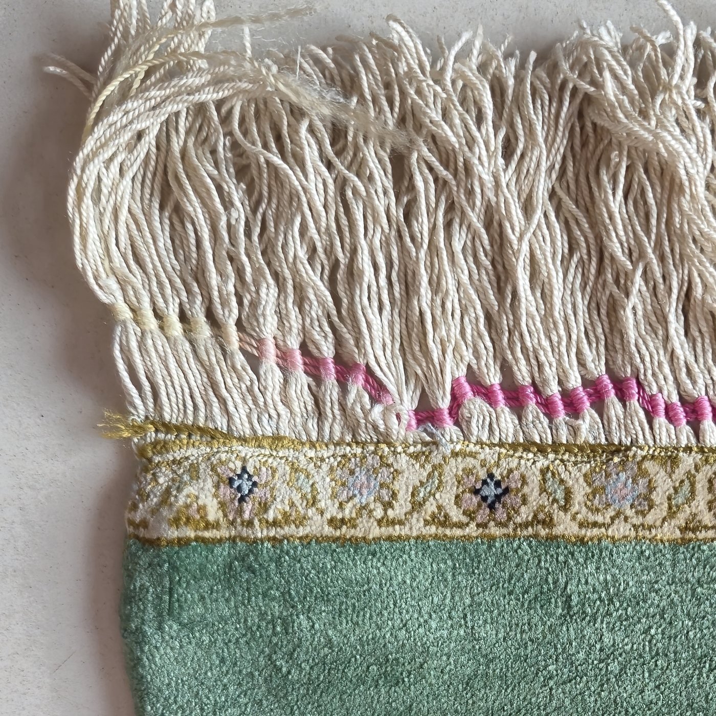 The same rug corner after restoration, fringe combed straight and selvedge rebuilt
