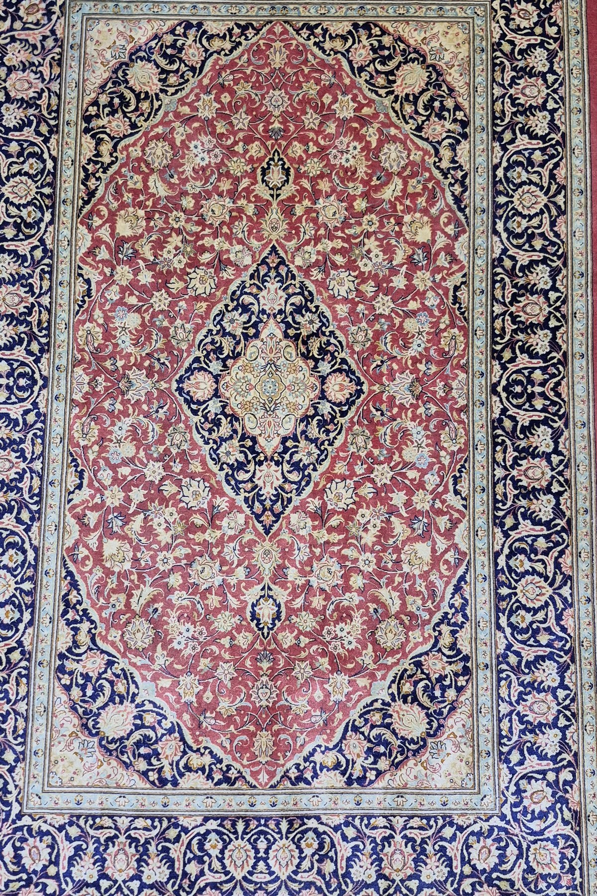 Red and navy silk Persian rug after hand washing